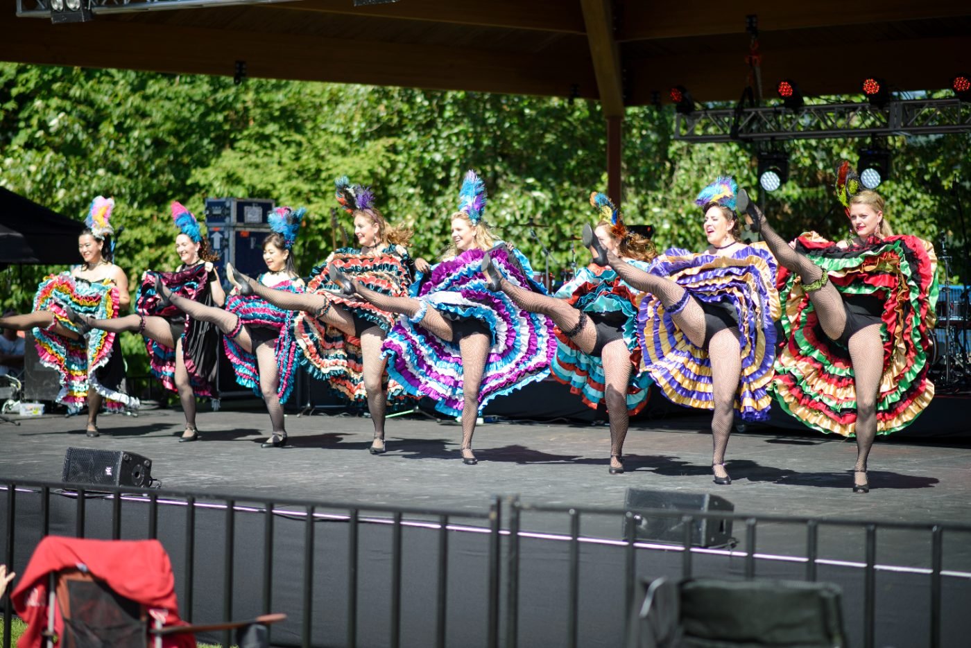 Cultural dance troupe performing in costume on an outdoor festival stage