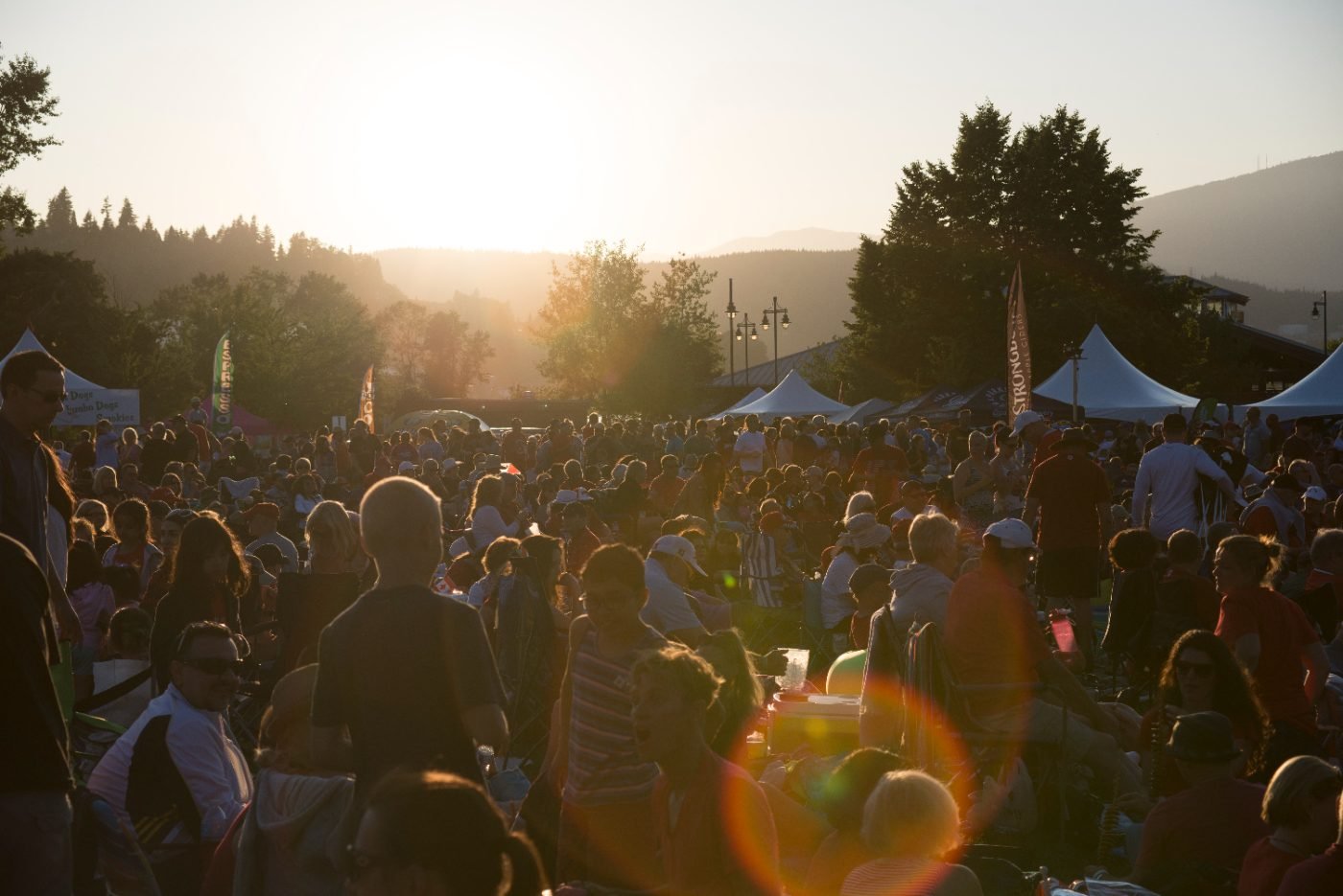 Festival crowd filling the waterfront park at sunset during Canada Day celebrations in Port Moody