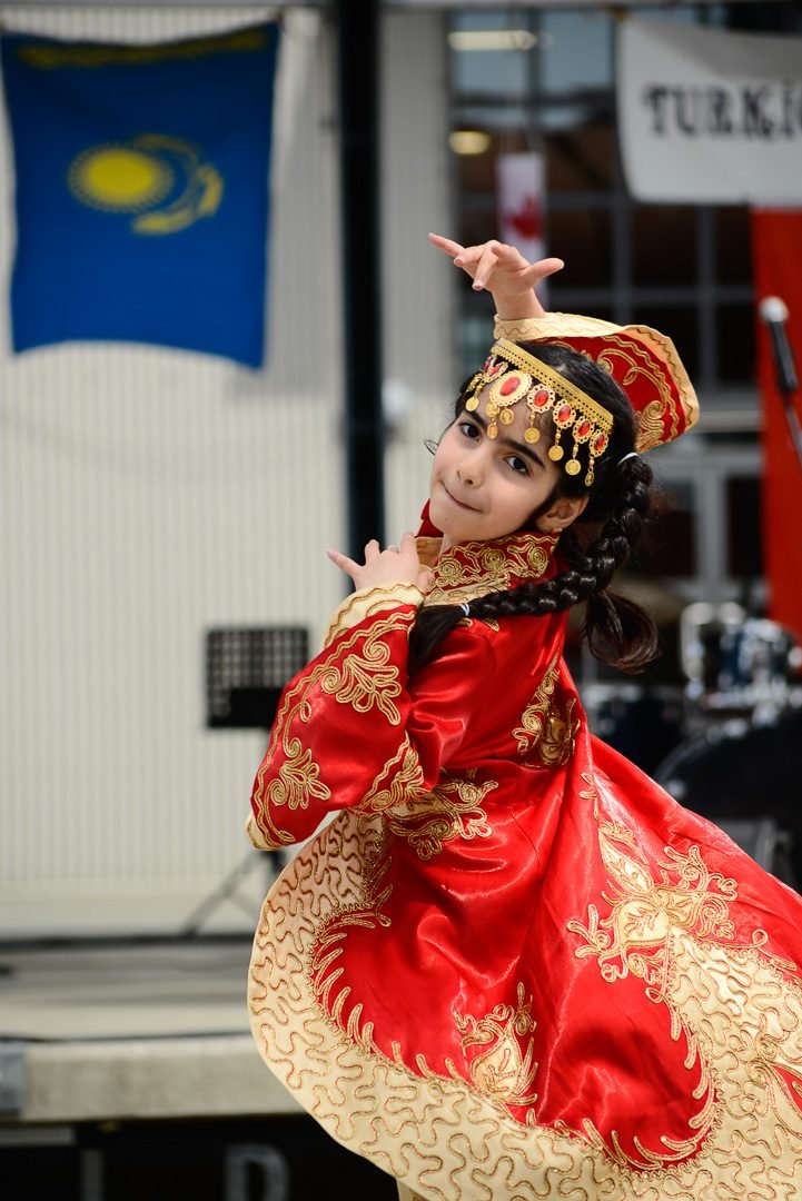 Festival dancer mid-spin in a red and gold traditional costume