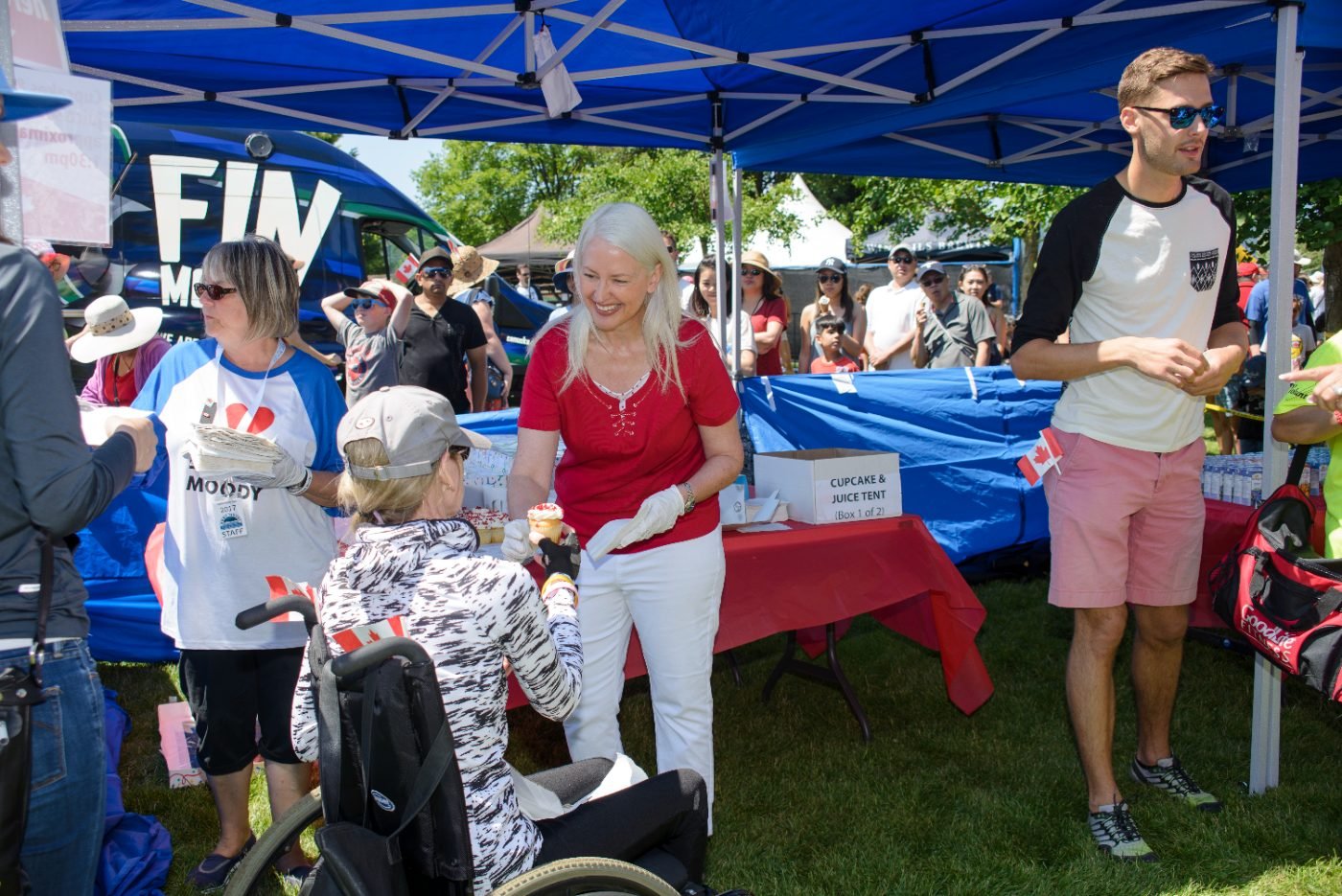 Festival volunteers handing out cupcakes and juice to visitors at the community tent