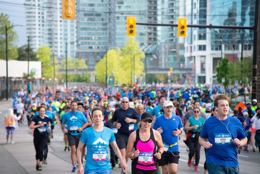 Lead pack of marathon runners photographed head-on along a downtown Vancouver street