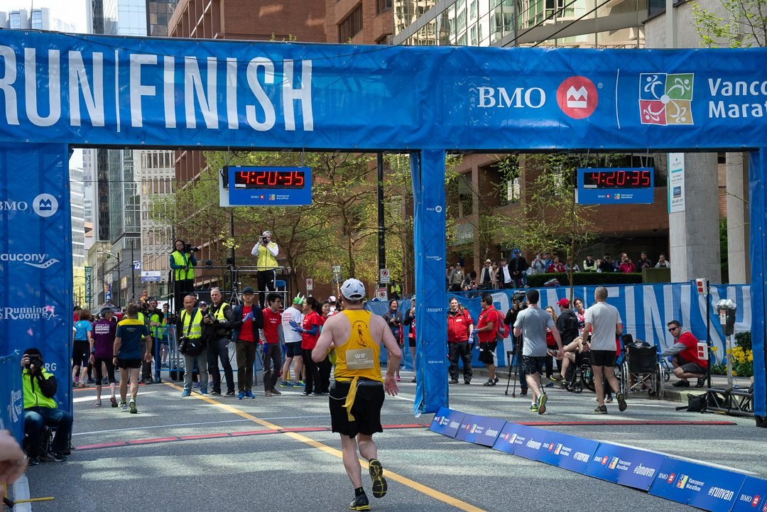 Runners crossing the finish line arch at the Vancouver marathon