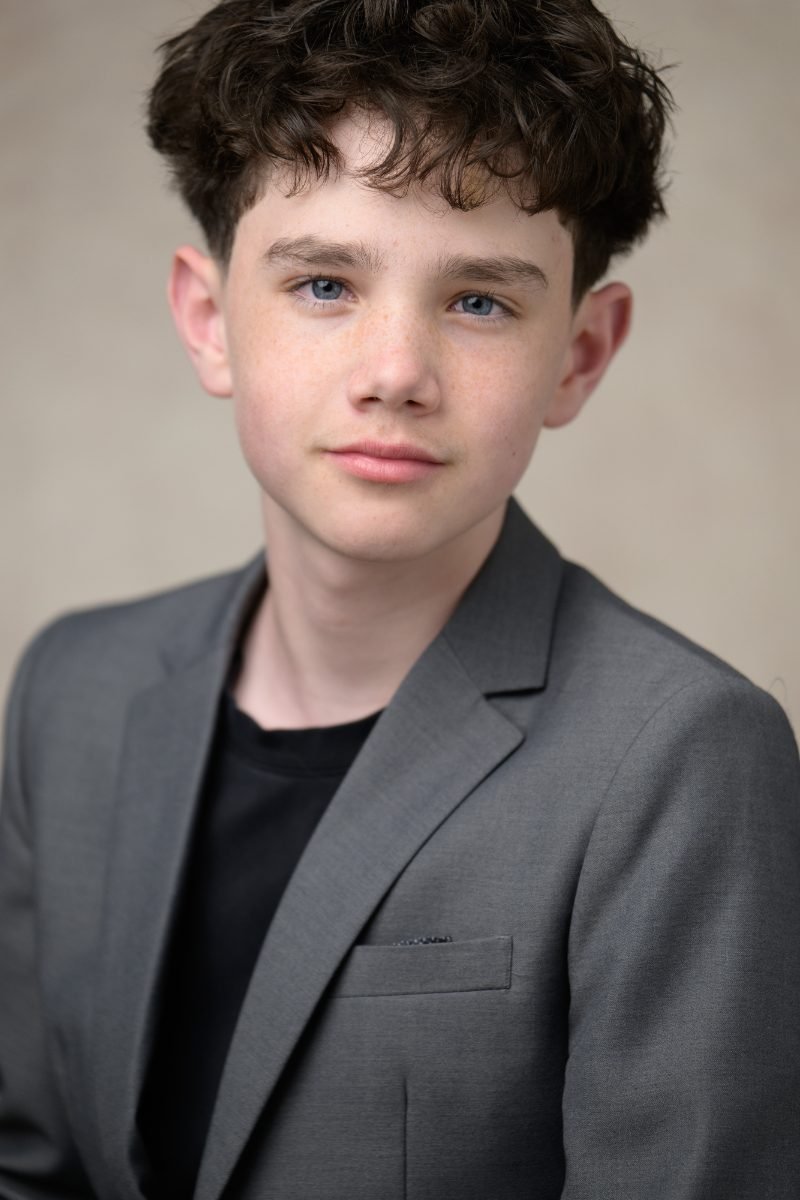 Actor headshot of a young performer in a grey blazer photographed in Vancouver