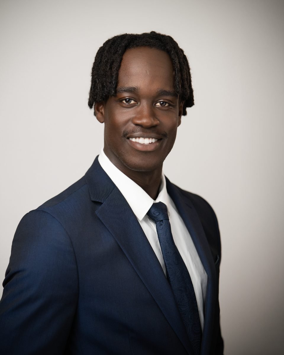 Lawyer headshot of Richard Mageto in a navy suit and tie