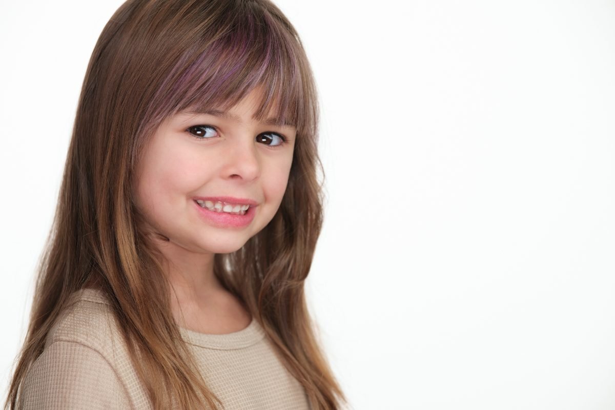 Smiling child actor headshot on a white background for casting