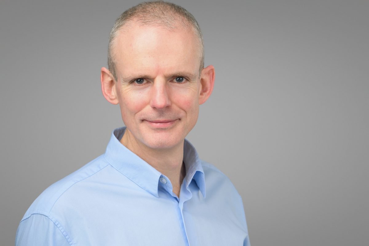 Corporate team headshot of Rich photographed for Arndt on a matching grey backdrop