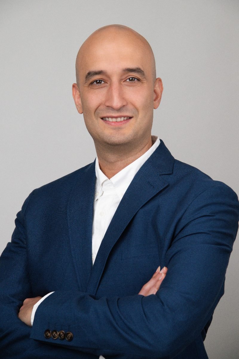Lawyer headshot of a man in a navy suit photographed for a firm website