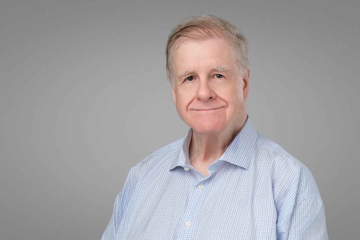 Team headshot of Neil Johnson of Collective Technologies on a grey backdrop