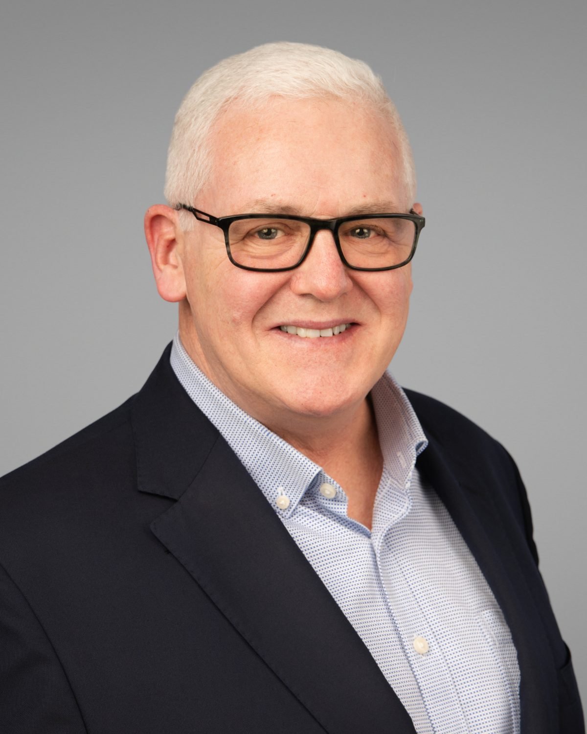 On-site headshot of John Garland in a navy blazer photographed at his office