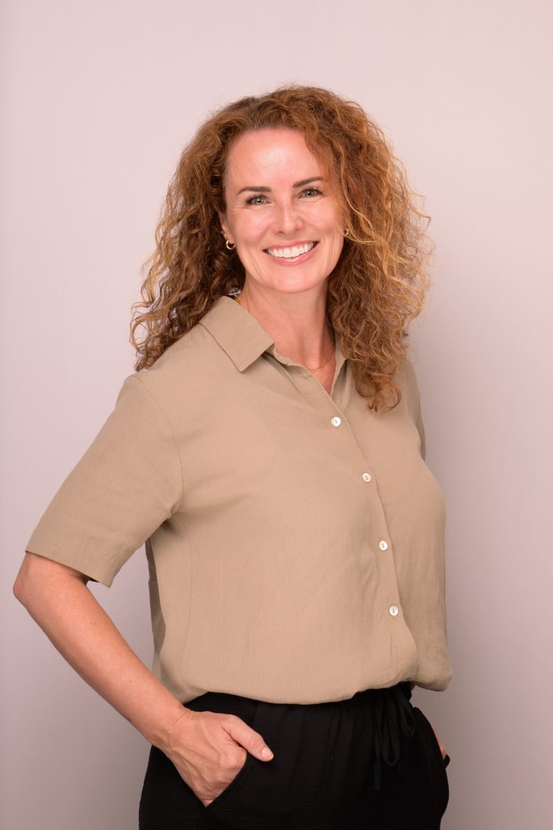 Personal branding headshot of Melanie Huck photographed on a soft pink backdrop