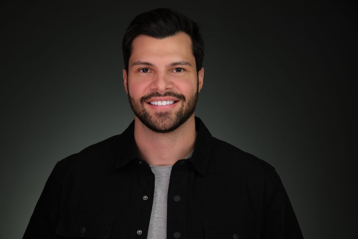 Personal branding headshot on a dark backdrop for speaking profiles