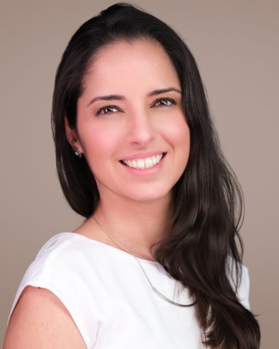 Professional headshot of Julia Coutinho photographed on a light grey backdrop