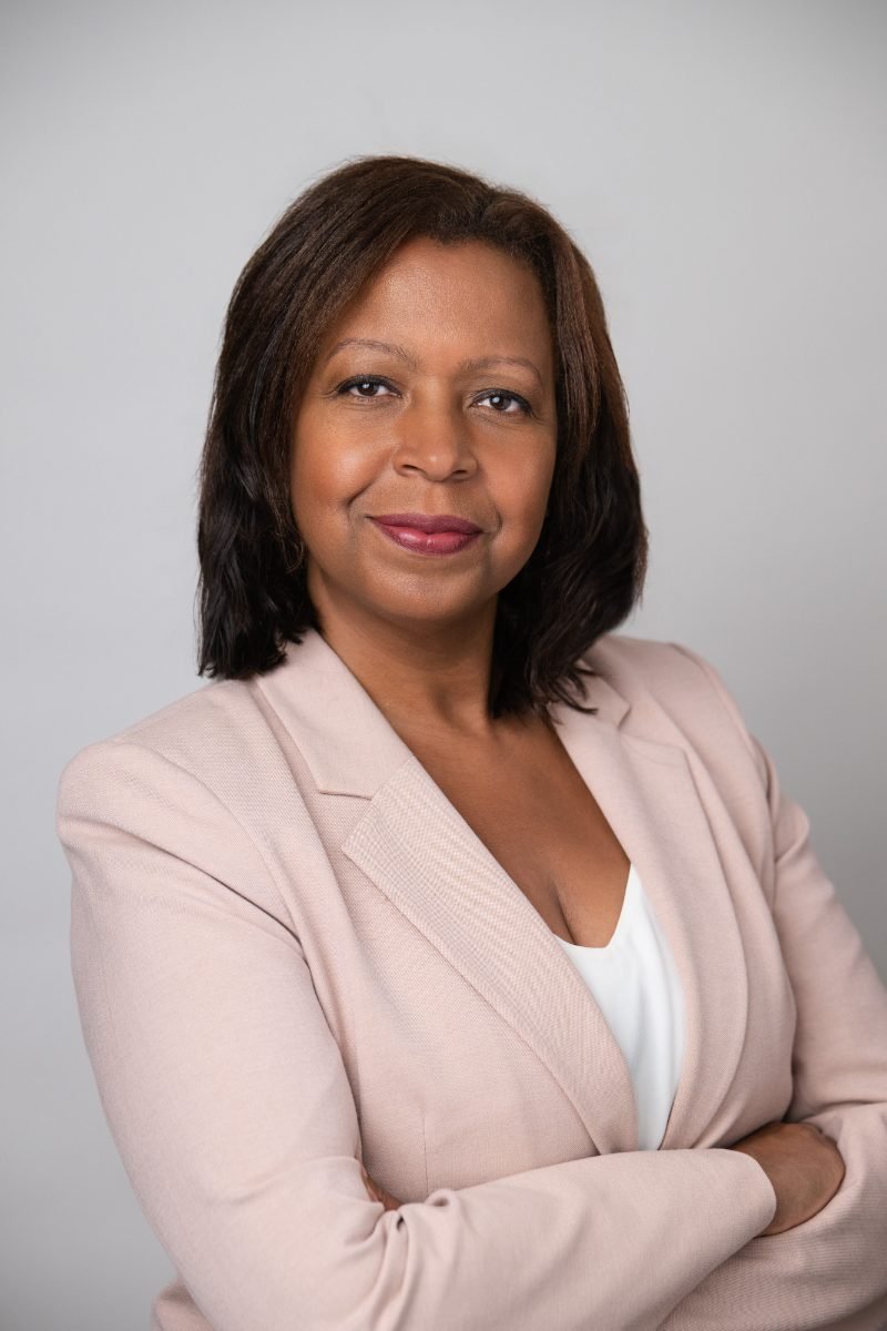 Lawyer headshot of a woman in a pink blazer photographed in the studio