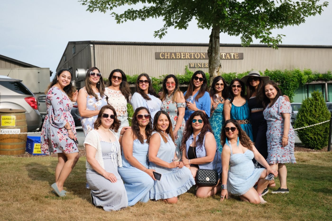 Baby shower guests seated together on the lawn for a group photo in the Fraser Valley