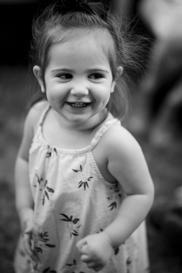 Black and white portrait of a toddler laughing at a family birthday party