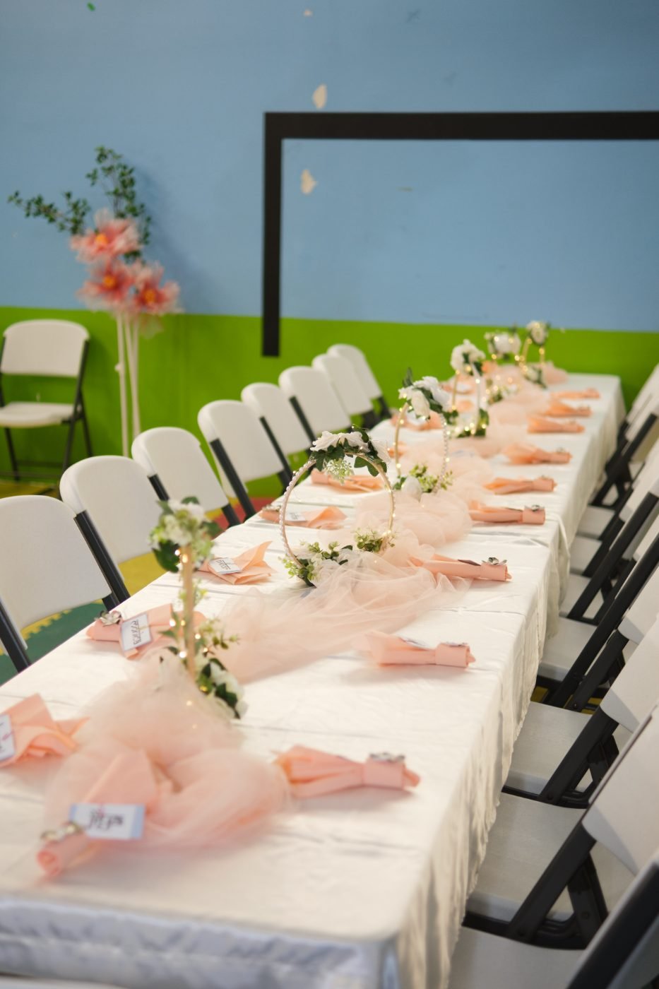Detail of a celebration table set with place cards, flowers and pastel decorations before guests arrive