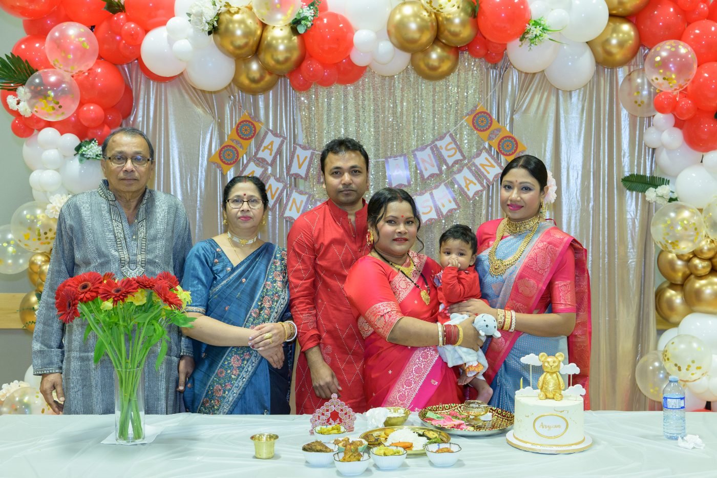 Extended family group photo taken at the decorated table during a cultural celebration