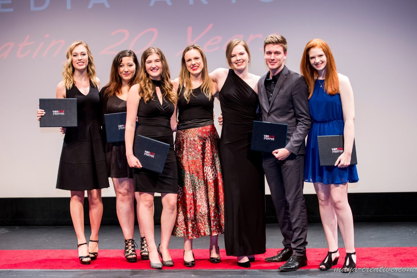 Graduates lined up on the red carpet with their diplomas at a graduation celebration in Vancouver