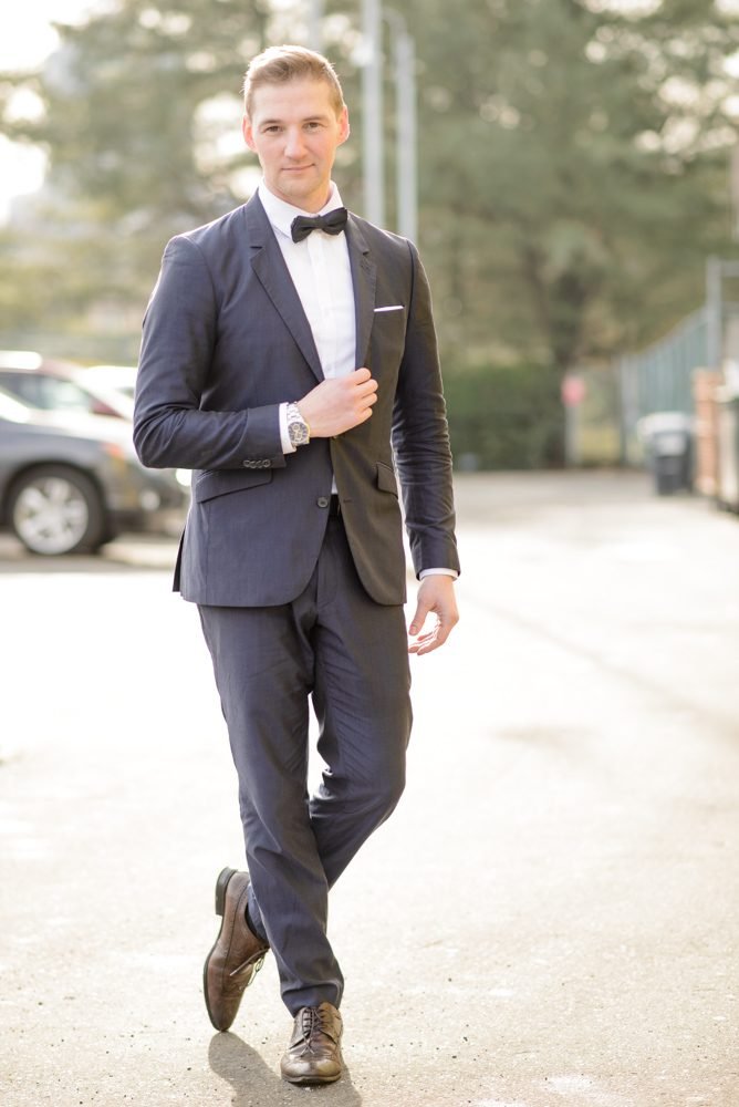 Full length groom portrait walking in a tailored navy suit before his wedding ceremony