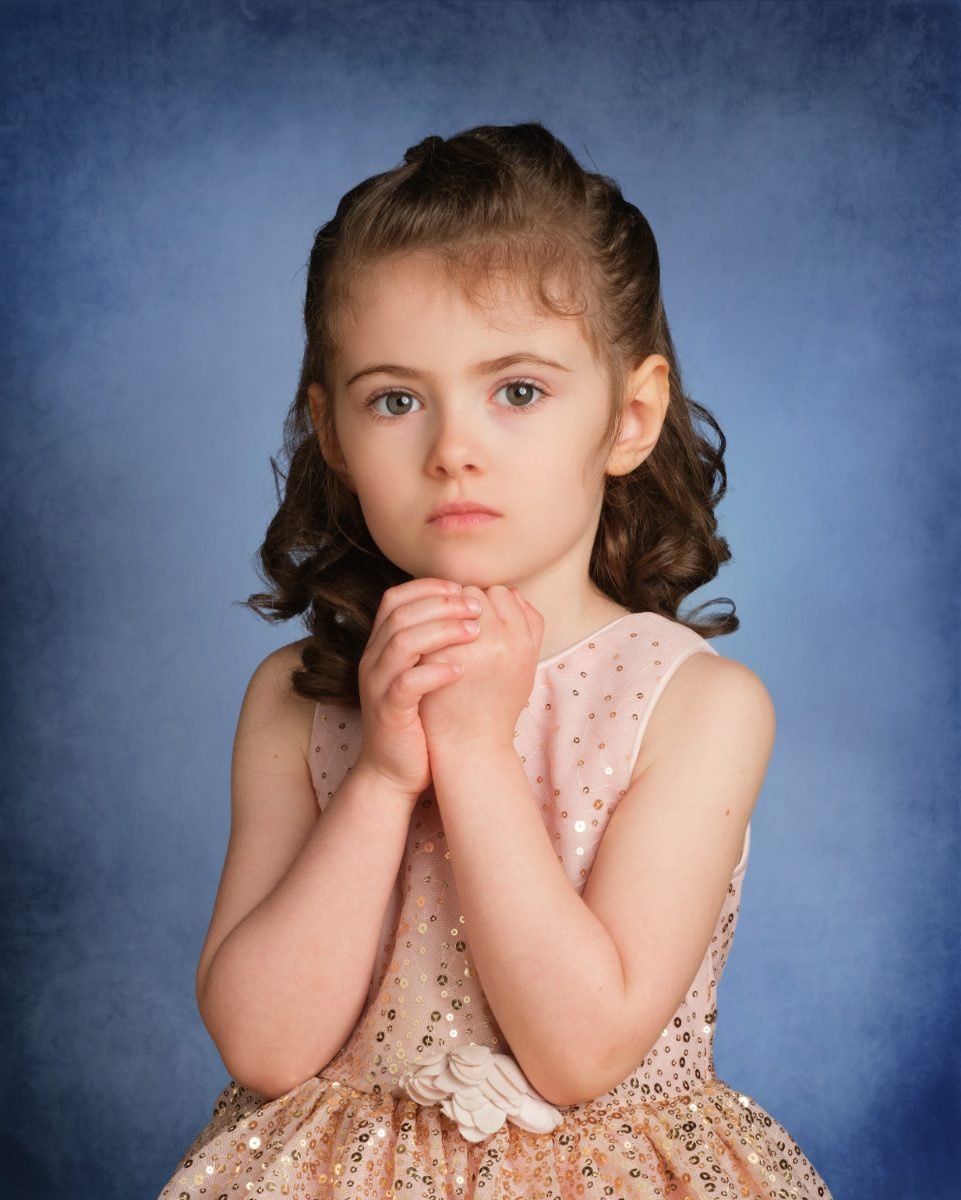 A student in a blush tulle dress photographed on picture day at her school