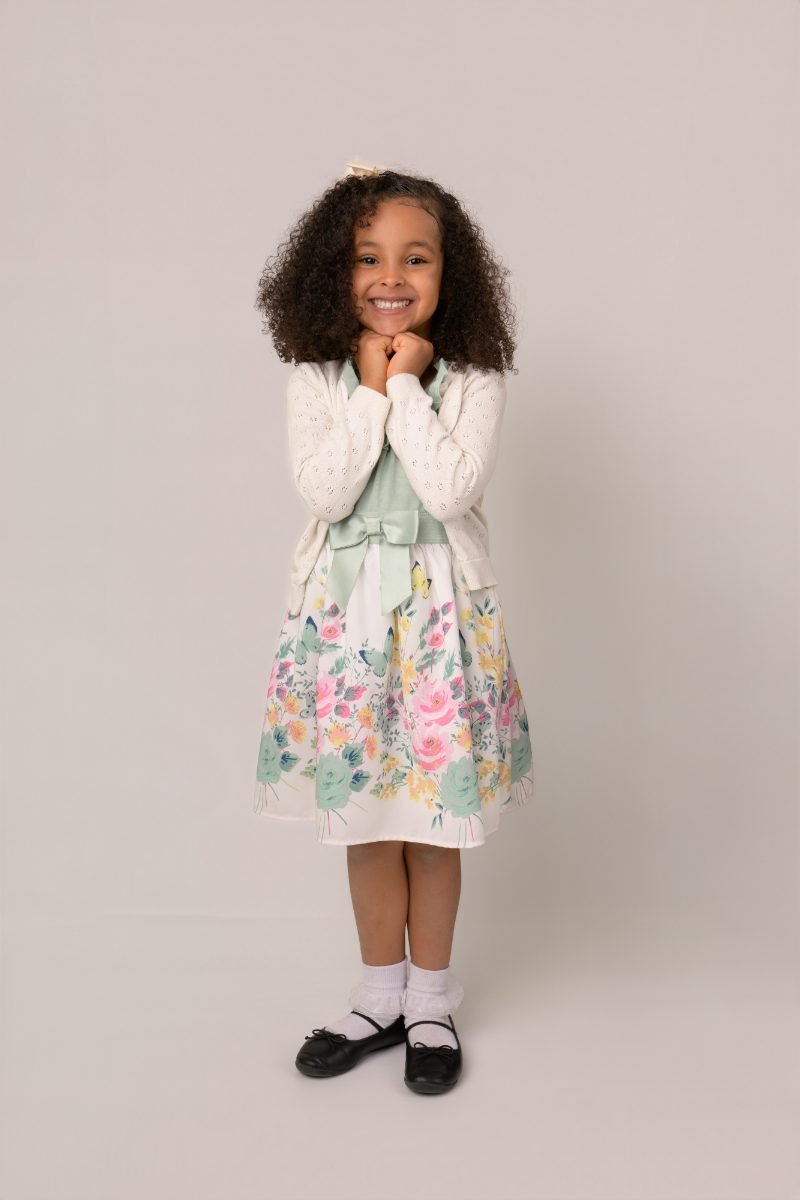 A girl in a floral dress photographed head to toe