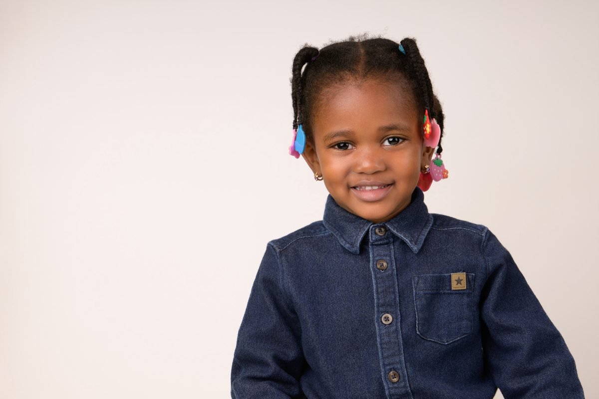 A girl in a denim shirt with beaded braids