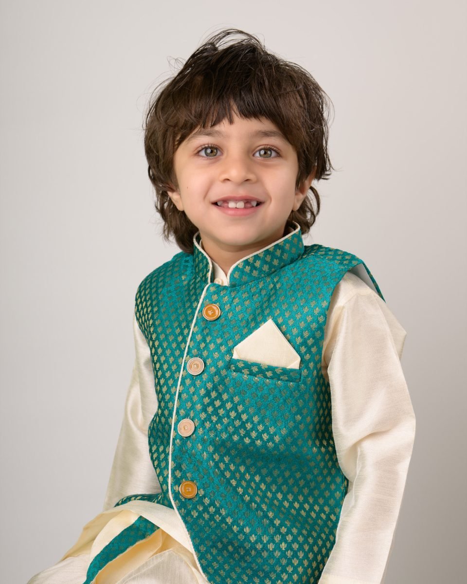A boy in an embroidered teal waistcoat