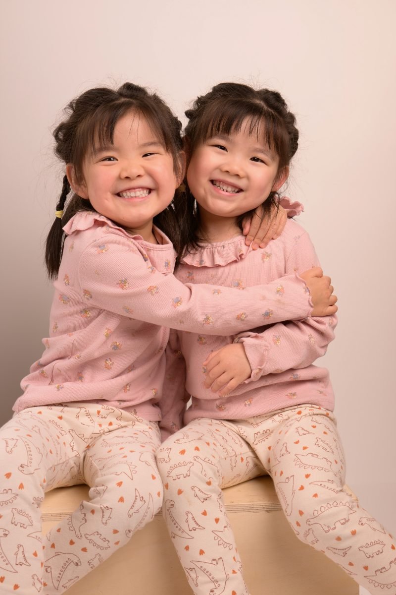 The same two sisters hugging cheek to cheek