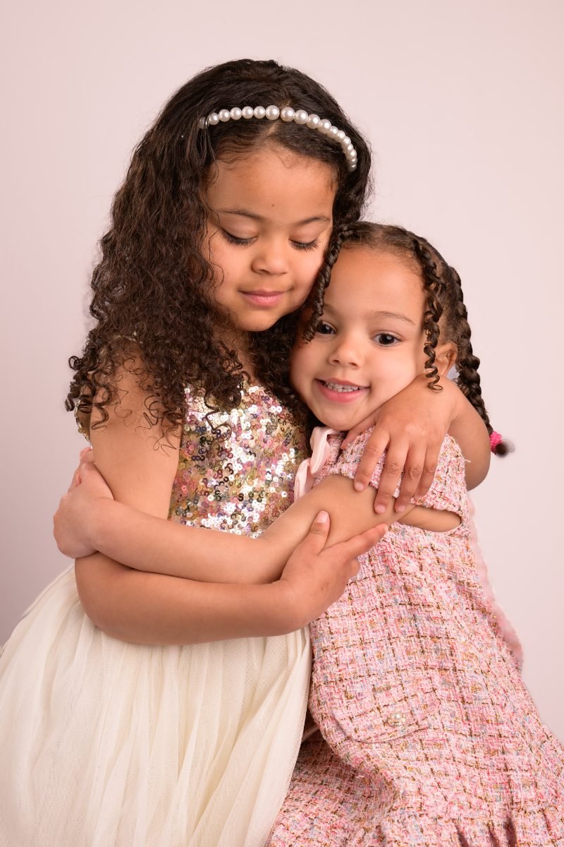 The same two sisters hugging with their eyes closed