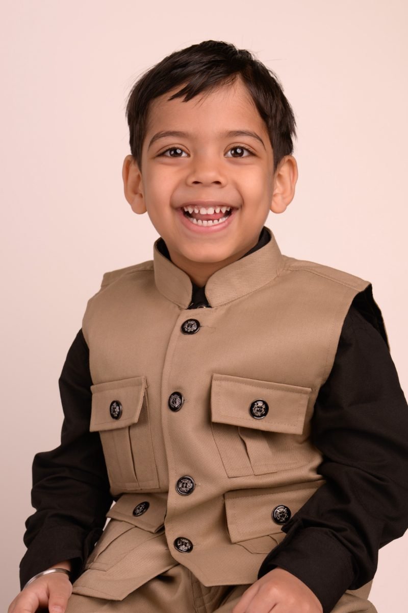 A boy in a tan waistcoat laughing