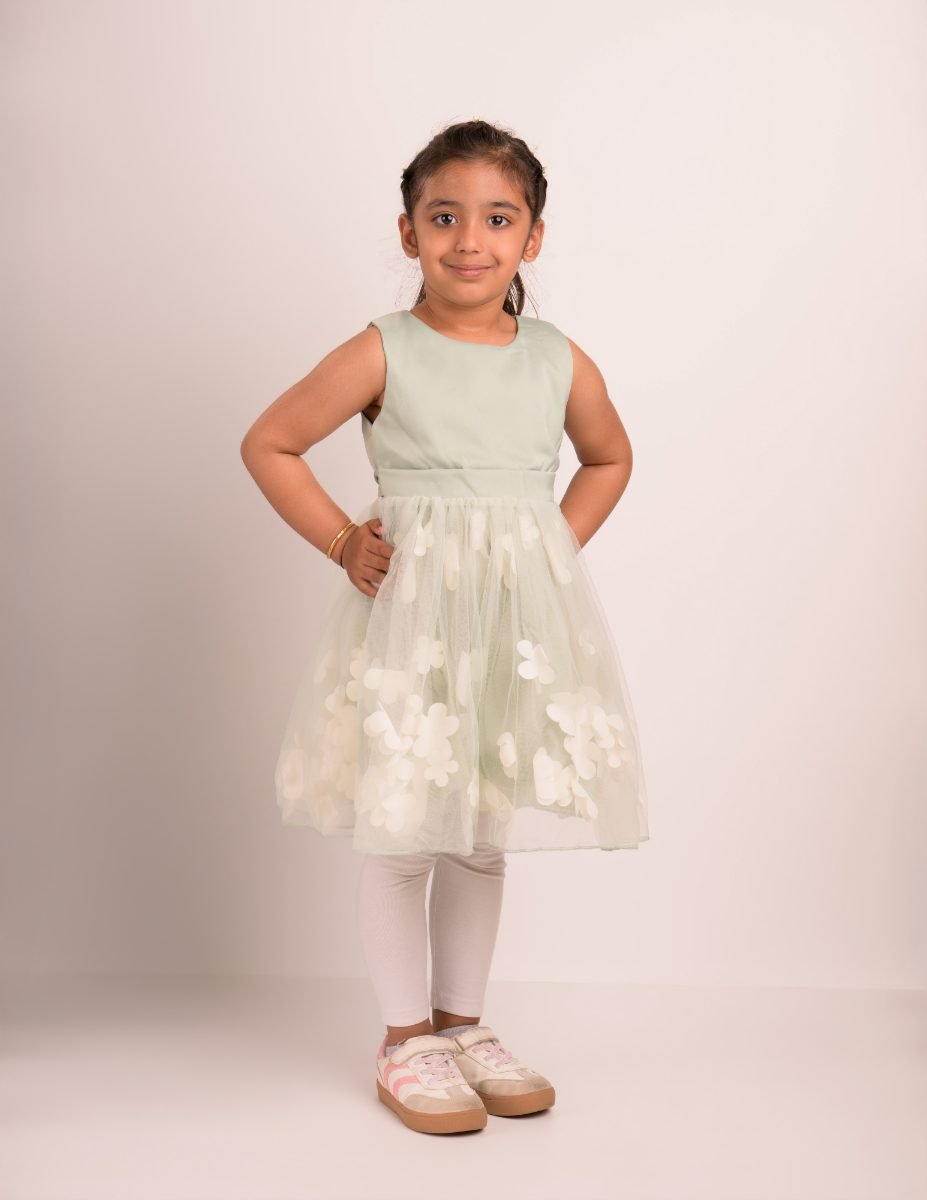 A girl in a mint dress standing with her hands on her hips