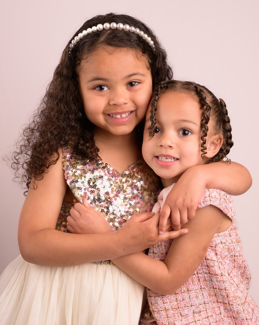 Two young sisters hugging during a preschool photo day sibling portrait