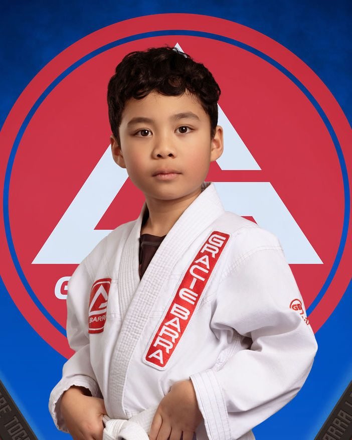 Young jiu-jitsu student portrait in a white gi at an academy photo day