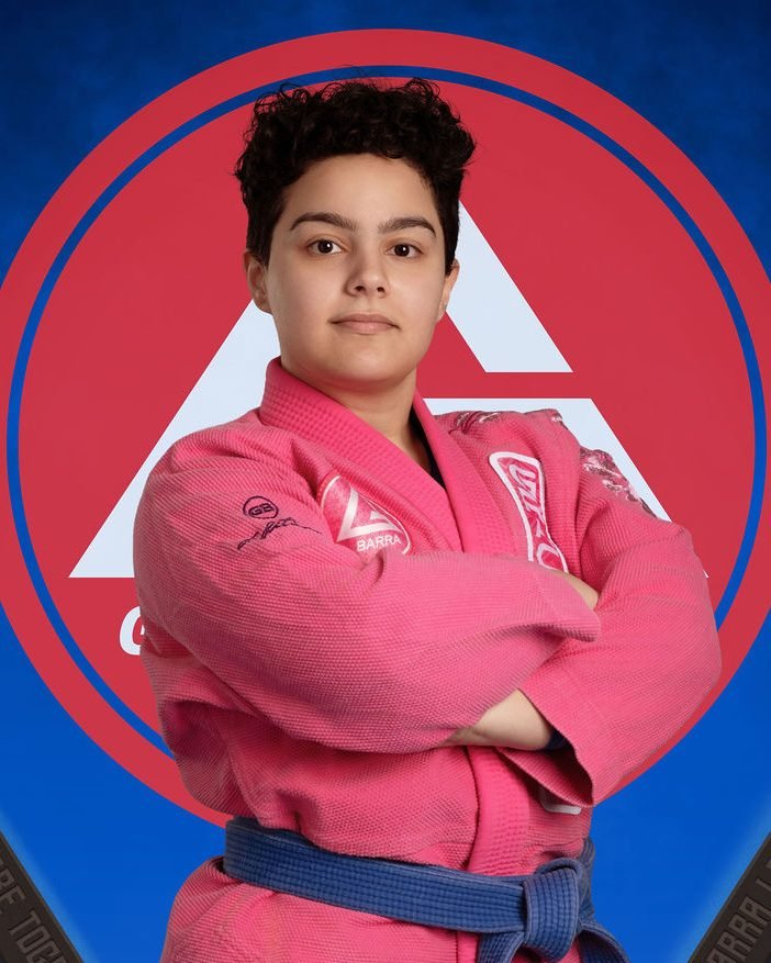 Jiu-jitsu student portrait in a pink gi with a blue belt