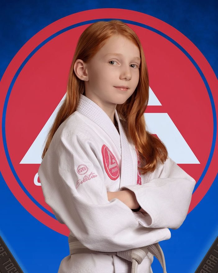 Young student in a white gi photographed for a jiu-jitsu academy photo day