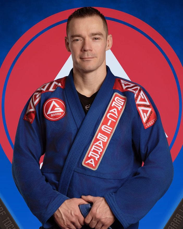 Adult jiu-jitsu instructor portrait in a navy gi for an academy website