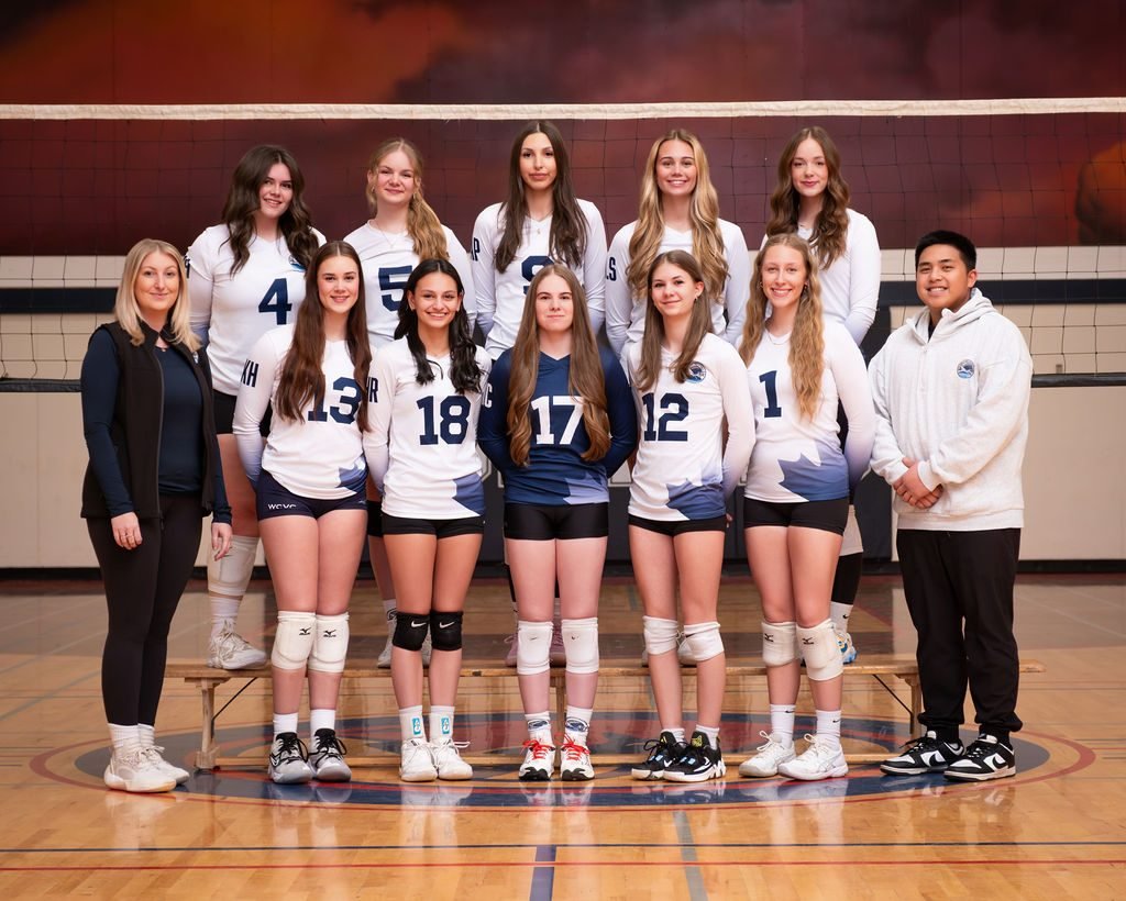 Girls volleyball club team photo with coaches on the gym floor at a photo night