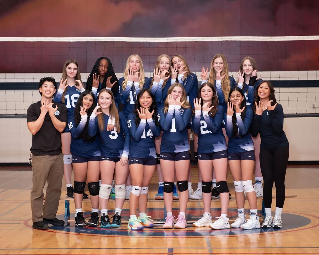 Youth volleyball team photographed with studio lighting on the court