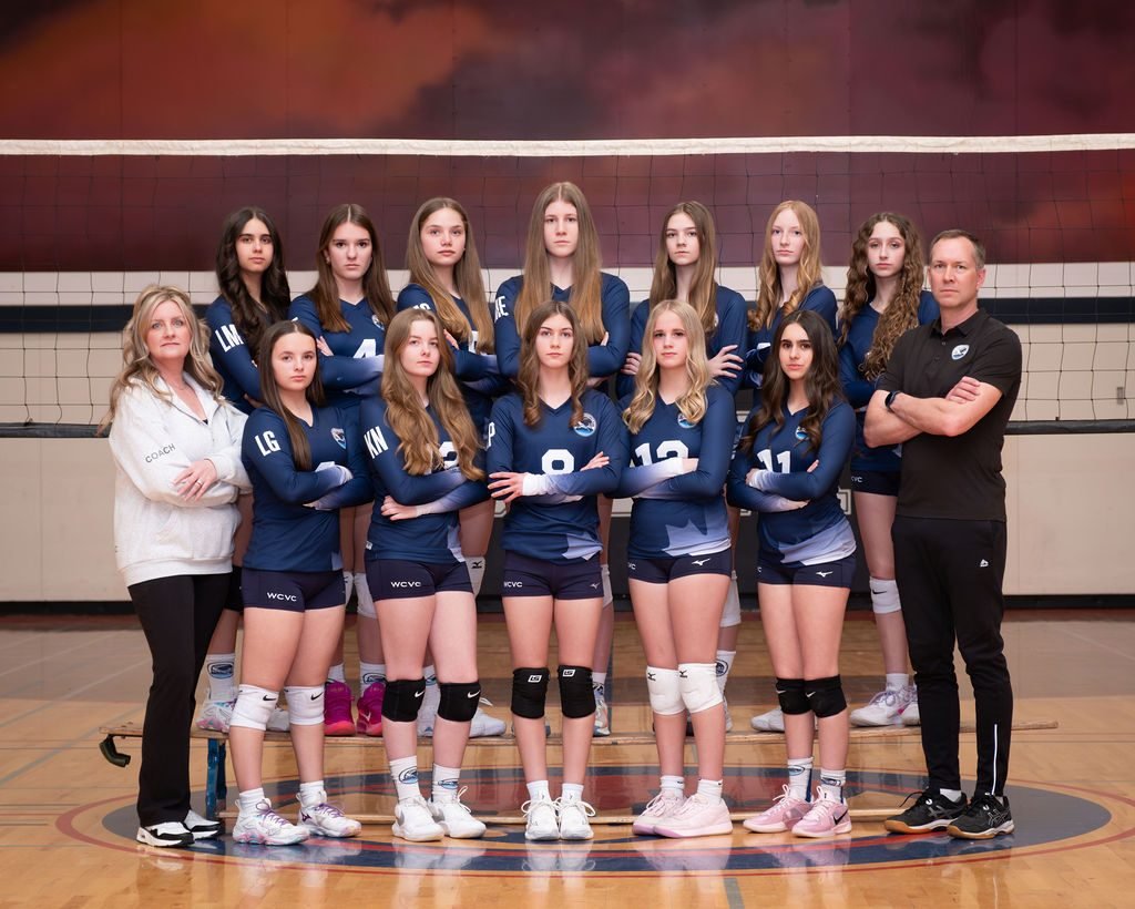 Club volleyball team photo with coaches, taken at a photo night in the team's own gym